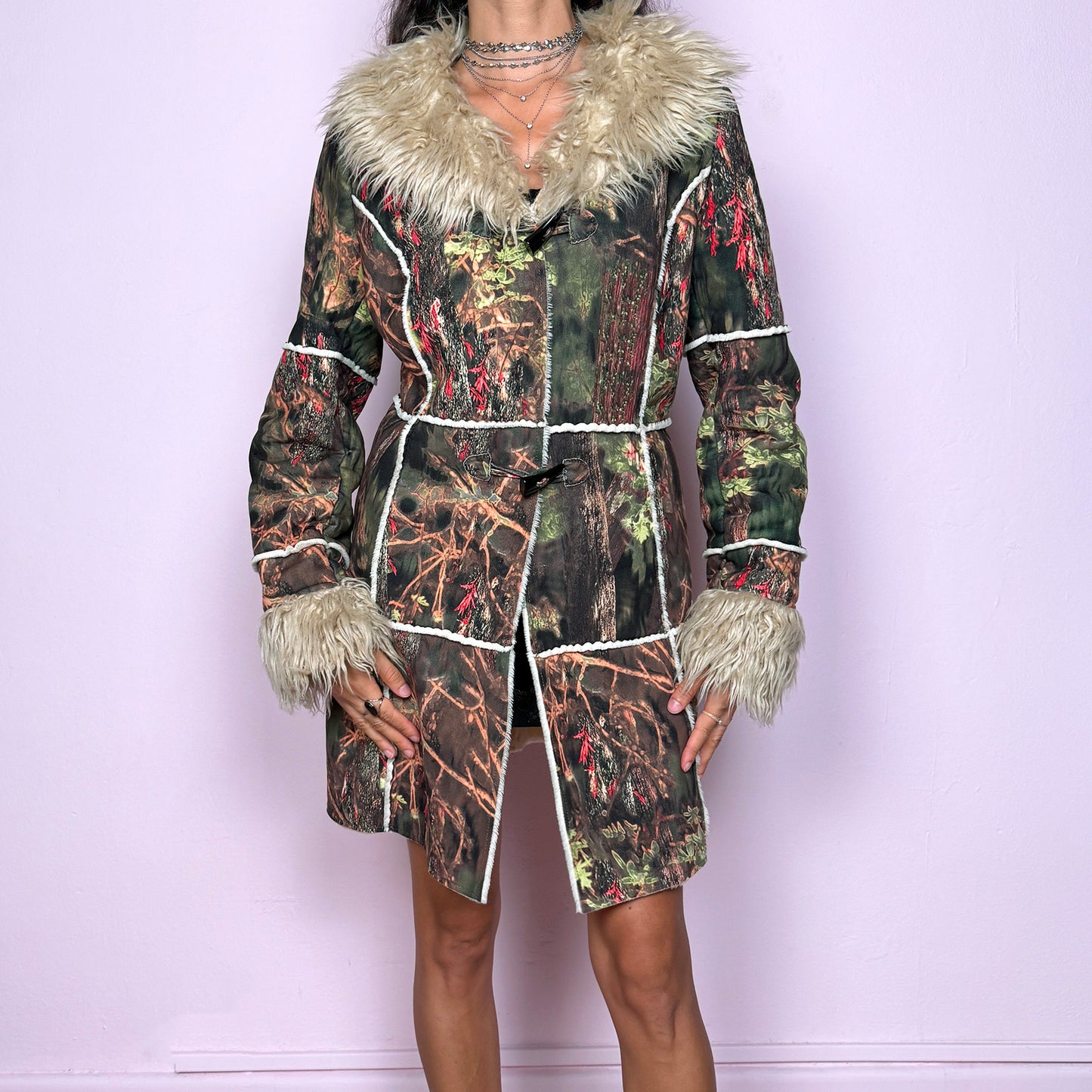 This vintage 2000s Penny Lane coat features a surreal forest graphic print in earthy greens, browns, and red tones, trimmed with plush beige faux fur at the collar and cuffs. Designed with toggle closures, contrast seams and pockets, it evokes fairycore and woodland Y2K energy with bohemian allure. Cozy yet bold, perfect for winter layering and statement street styling. A collectible archive outerwear piece. Made from warm polyester blend. Excellent vintage condition.
