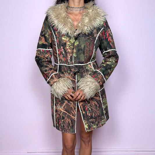 This vintage 2000s Penny Lane coat features a surreal forest graphic print in earthy greens, browns, and red tones, trimmed with plush beige faux fur at the collar and cuffs. Designed with toggle closures, contrast seams and pockets, it evokes fairycore and woodland Y2K energy with bohemian allure. Cozy yet bold, perfect for winter layering and statement street styling. A collectible archive outerwear piece. Made from warm polyester blend. Excellent vintage condition.
