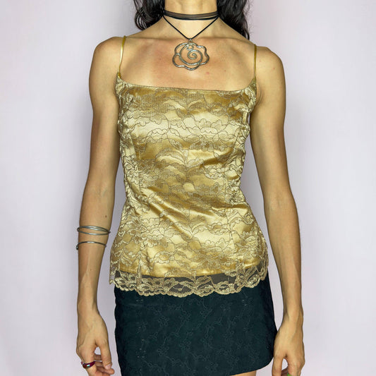 The Y2K Gold Lace Corset Top is a vintage 2000s formalwear piece featuring delicate floral lace over a satin-finish base in soft gold. It’s structured with subtle boning, spaghetti straps, and a back zipper closure for a sculpted fit. The hem is finished with scalloped lace trim. A refined option ideal for evening galas, formal parties, bridal moments, or prom nights. Excellent vintage condition.