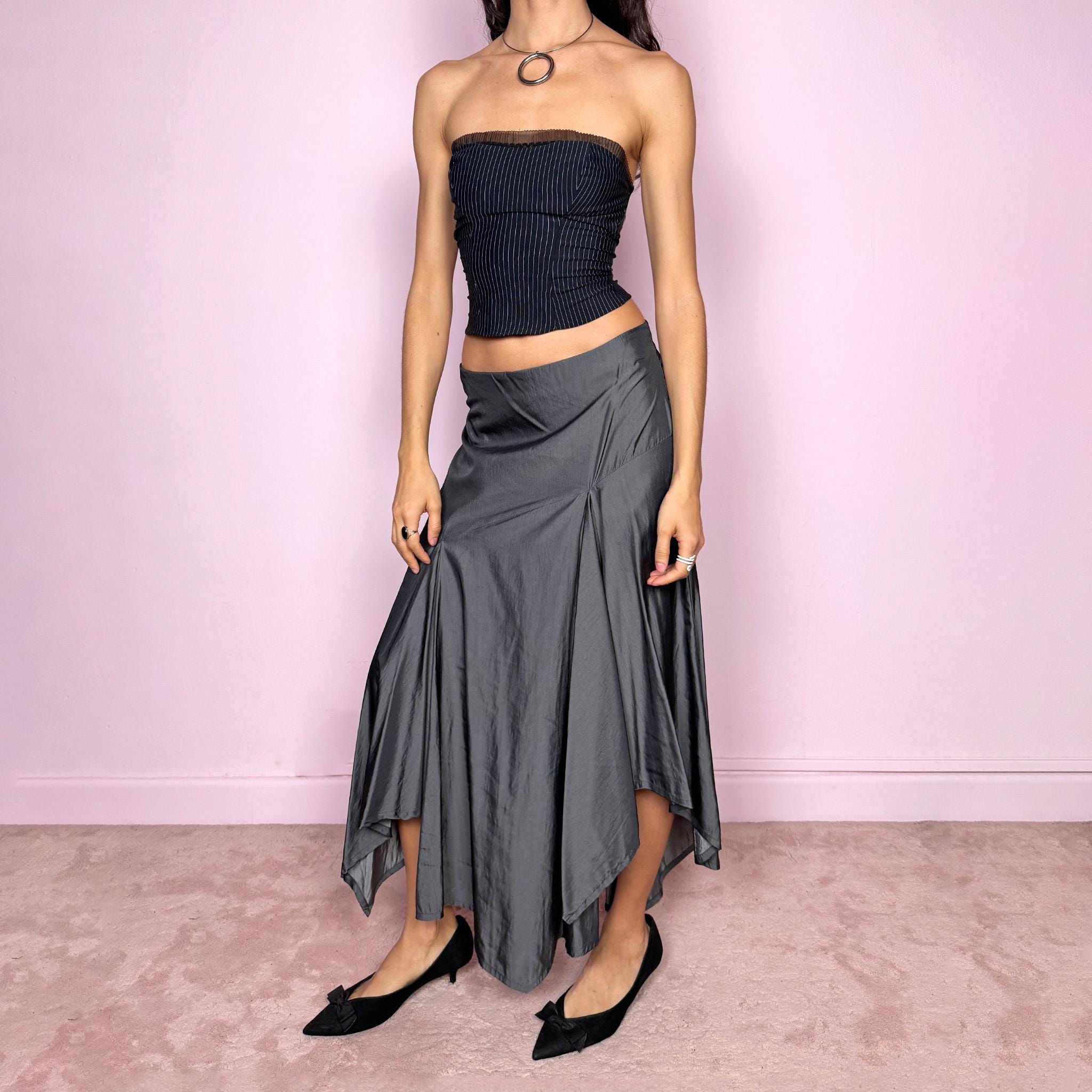 Vintage 2000s silver gray midi skirt with an avant garde asymmetric deconstructed design and fluid godet panel details. Features a glossy satin-like finish, no stretch structure, and back zip closure. Can be worn low rise for size S or mid rise for size M. Perfect for formal, statement, or evening wear. Made from a polyester viscose blend. Excellent vintage condition.