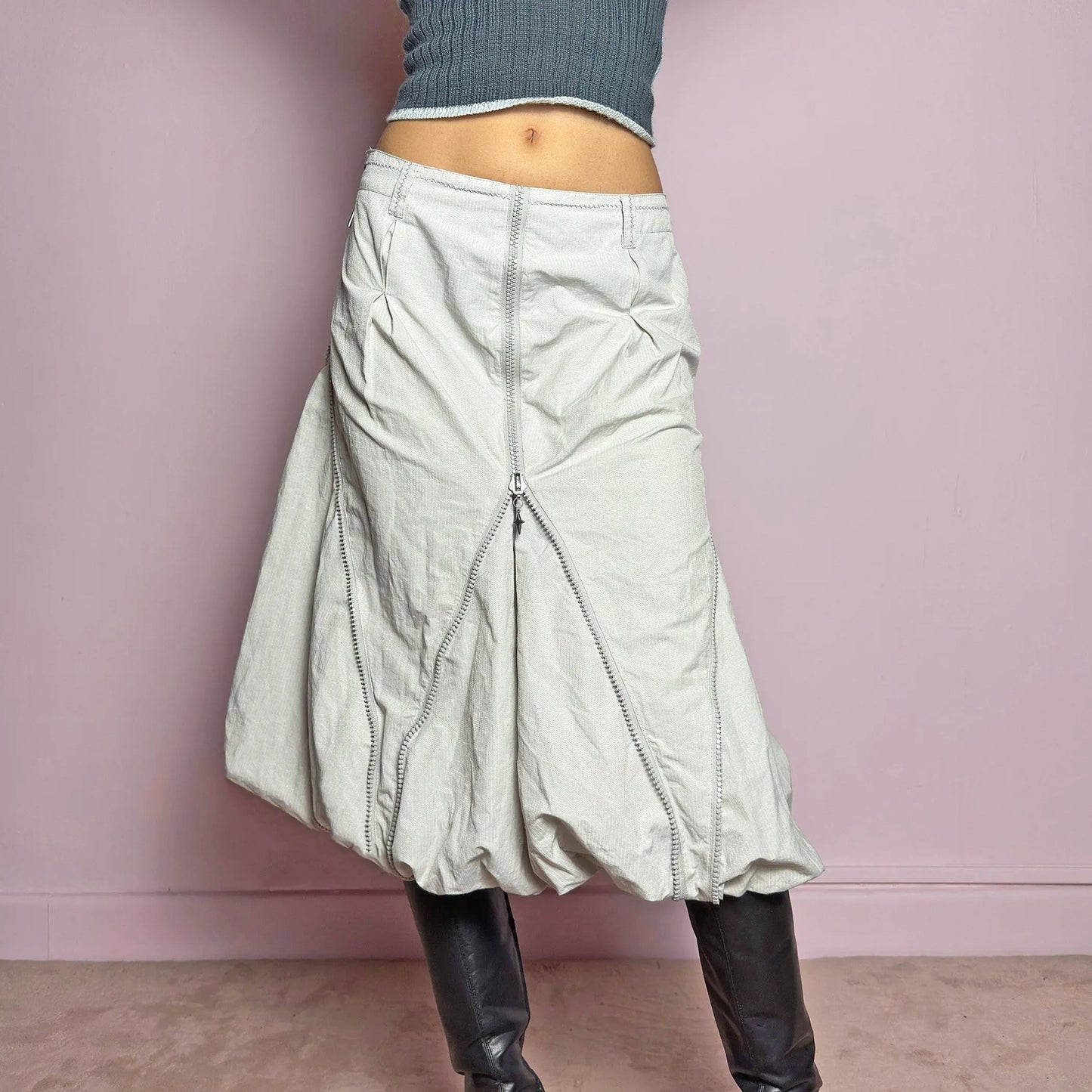 The Y2K Gray Bubble Midi Skirt is a futuristic statement 2000s piece featuring a voluminous bubble silhouette with multiple zipper details that create a dynamic, adjustable shape. Designed with a structured high-rise fit, and a side zipper closure, this skirt is perfect for bold streetwear outfits. Great vintage condition.