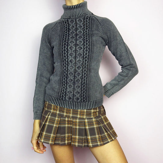 The Y2K Washed Gray Turtleneck Sweater is a vintage 2000s piece, featuring a slightly faded gray tone for a worn-in, effortless look. Designed with an intricate cable knit pattern on the front, ribbed cuffs, and a thick turtleneck, it offers both warmth and style. Ideal for preppy, academia, or casual winter outfits. Made from a cotton blend knit. Great vintage condition.