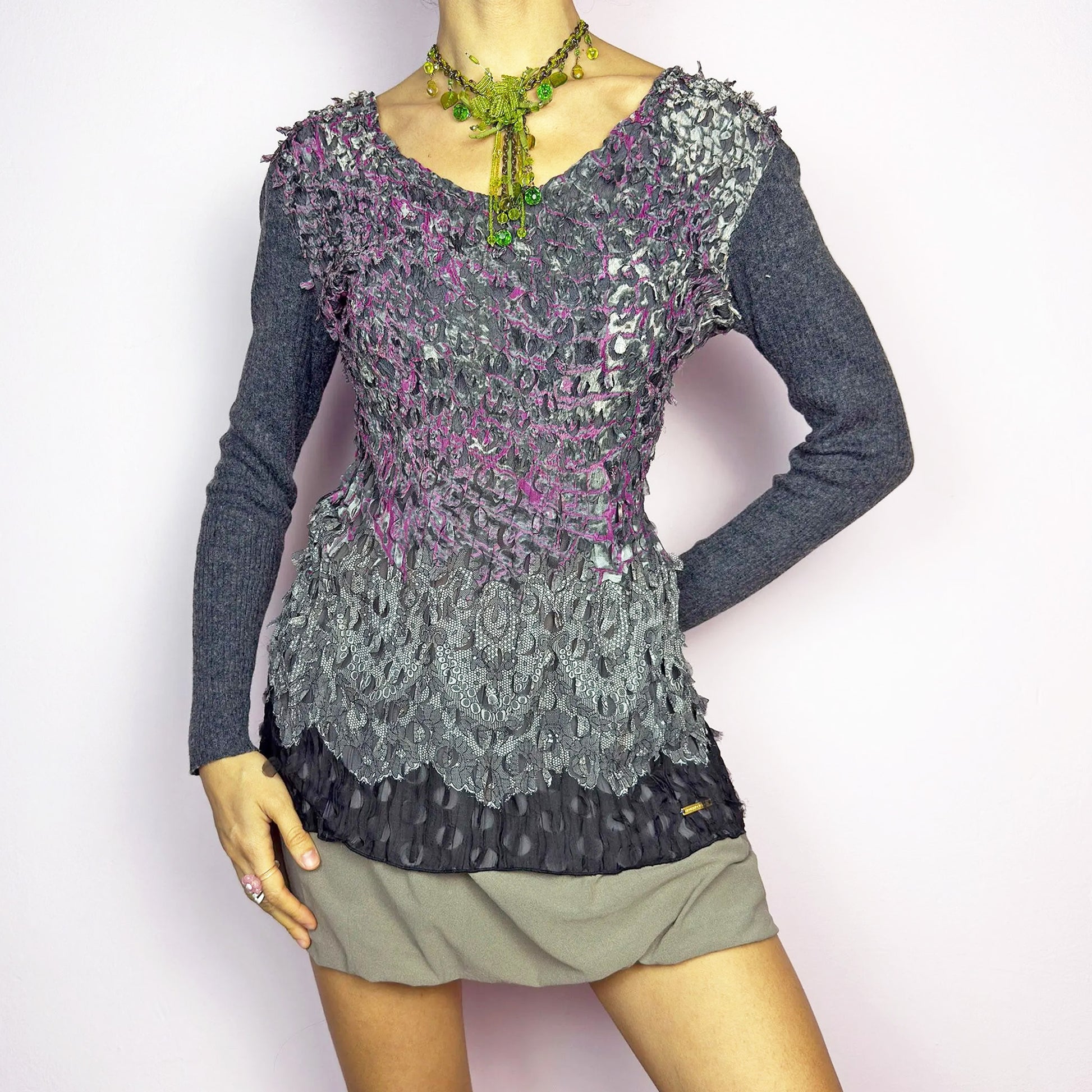 The Y2K Gray Crinkled Textured Top is a vintage 2000s piece by designer Roberto Verino, featuring a unique sheer overlay with delicate cut-out details that create a dimensional, deconstructed look. The long knit sleeves contrast beautifully with the intricate textures, adding depth to this stretchy fit design. A standout piece for those who love avant-garde fashion. Excellent vintage condition.