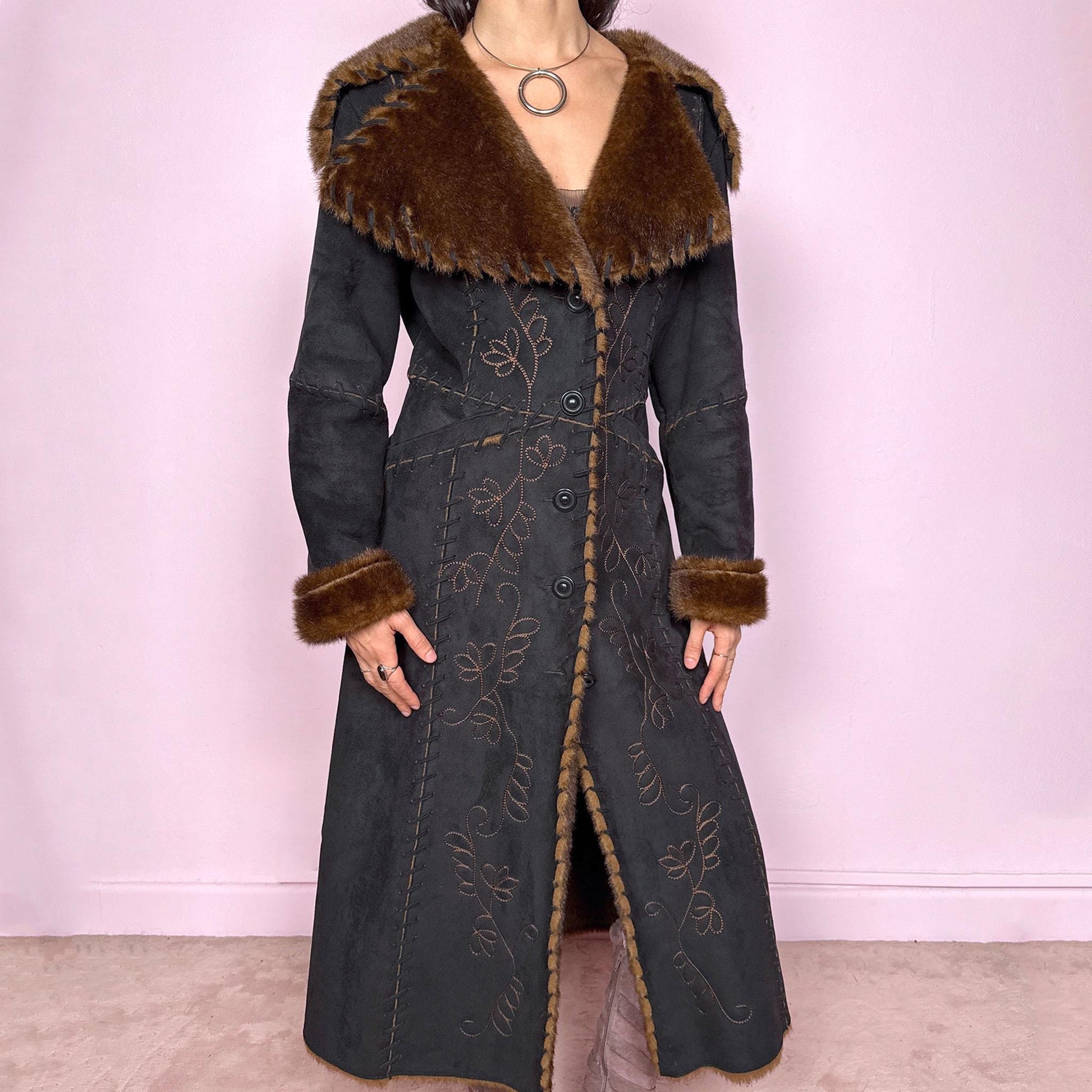Stunning vintage 2000s dark gray almost black long Penny Lane coat with brown faux fur interior, collar, and cuffs. Features intricate floral embroidery, pockets, and button front closure. Soft faux suede with a warm feel, ideal for whimsical fairycore, boho, forest muse, and 70s Afghan-inspired Y2K styling. French-designed piece. Made from polyester. Excellent vintage condition.