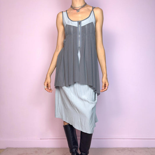This vintage 2000s midi dress features layered grey tones in mixed textures, including a pleated mesh overlay with faux front zip detail and a side zipper closure. The sleeveless cut and flared asymmetric drape create sculptural movement. Falls below the knee, lightweight, with no stretch. A deconstructed Y2K silhouette—futuristic, quiet, and avant-garde. Perfect for summer days or experimental night looks. Excellent vintage condition.