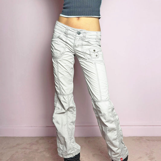 The Y2K Gray Low-Rise Pants are a vintage 2000s piece featuring a lightweight, structured fabric with a washed gray tone. Designed with a low-rise waist, button and zipper closure, and pockets, these pants offer a cropped, relaxed straight-leg fit with contrast stitching and panel detailing for a utilitarian-inspired aesthetic. Perfect for streetwear and casual grunge looks.