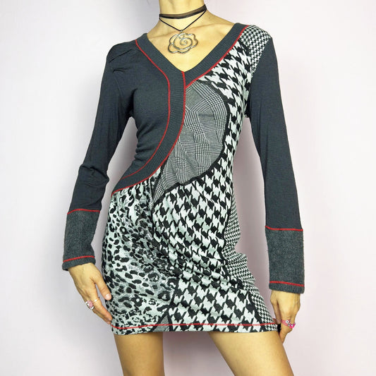The Y2K Gray Patchwork Mini Dress is a vintage 2000s piece featuring a bold patchwork print with a mix of houndstooth, plaid, and leopard patterns, a V-neckline and long sleeves. The fitted silhouette is accentuated with contrast red stitching. Made from a stretchy fabric, it offers a flattering fit. Ideal for casual streetwear or a night-out ensemble.