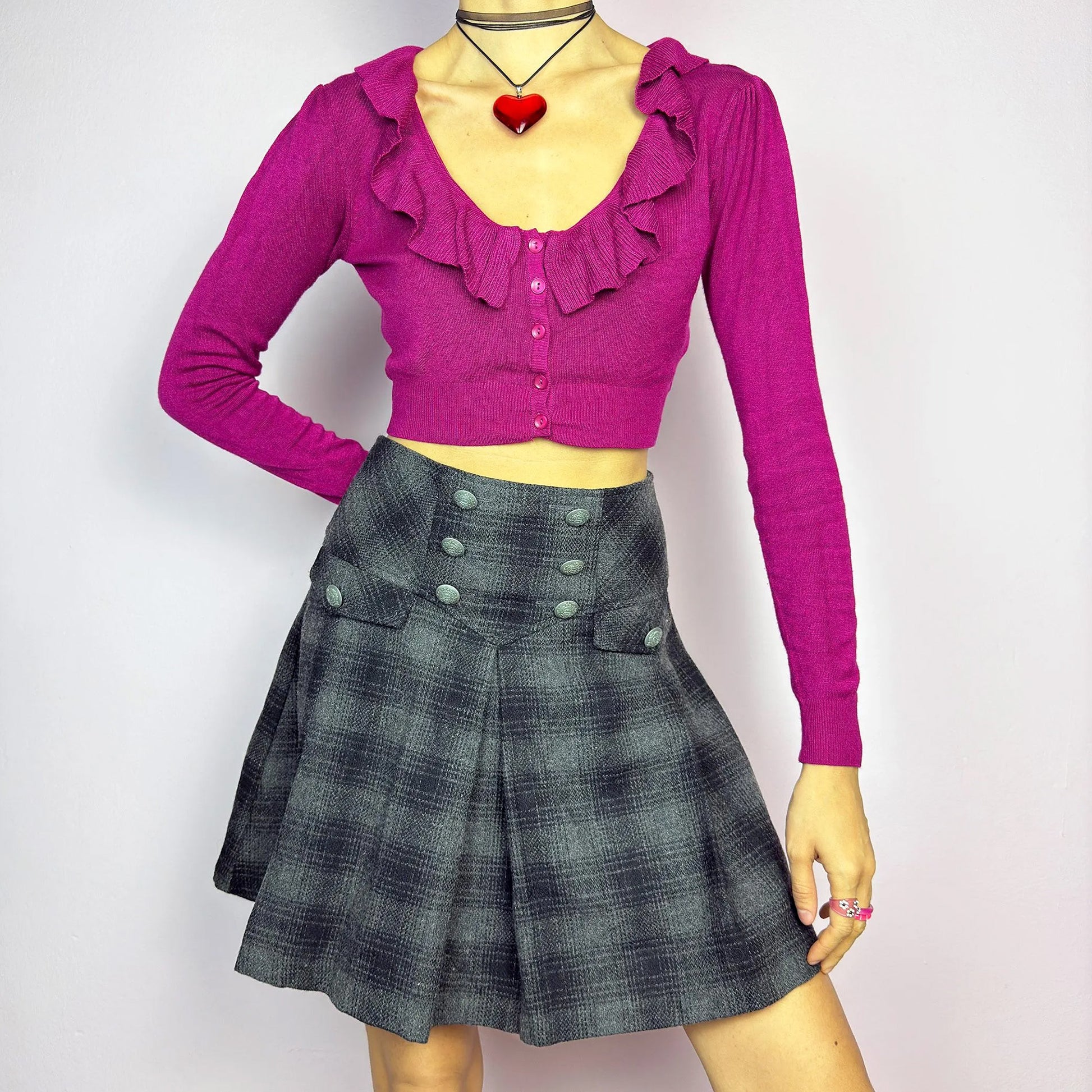 The Y2K Gray Plaid Pleated Mini Skirt is a vintage 2000s essential, featuring a structured pleated design with decorative button details. Made from a thick woven fabric with a black plaid pattern, it is ideal for winter outfits. It also has a back zipper closure. Perfect for preppy, grunge, or casual looks. Great vintage condition.