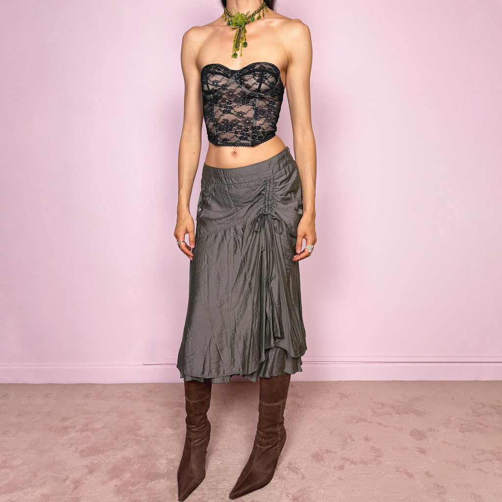 Vintage 2000s greenish-gray layered midi skirt featuring a fluid draped silhouette, ruched side detail with tie accents, and a softly flared layered hem. Designed in a non-stretch 83% viscose-blend fabric with a side zip closure and full polyester lining, the skirt has an avant-garde deconstructed aesthetic. Can be worn high-waisted for size L or lower-rise for M. Great vintage condition.