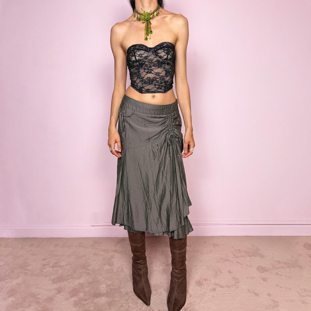 Vintage 2000s greenish-gray layered midi skirt featuring a fluid draped silhouette, ruched side detail with tie accents, and a softly flared layered hem. Designed in a non-stretch 83% viscose-blend fabric with a side zip closure and full polyester lining, the skirt has an avant-garde deconstructed aesthetic. Can be worn high-waisted for size L or lower-rise for M. Great vintage condition.