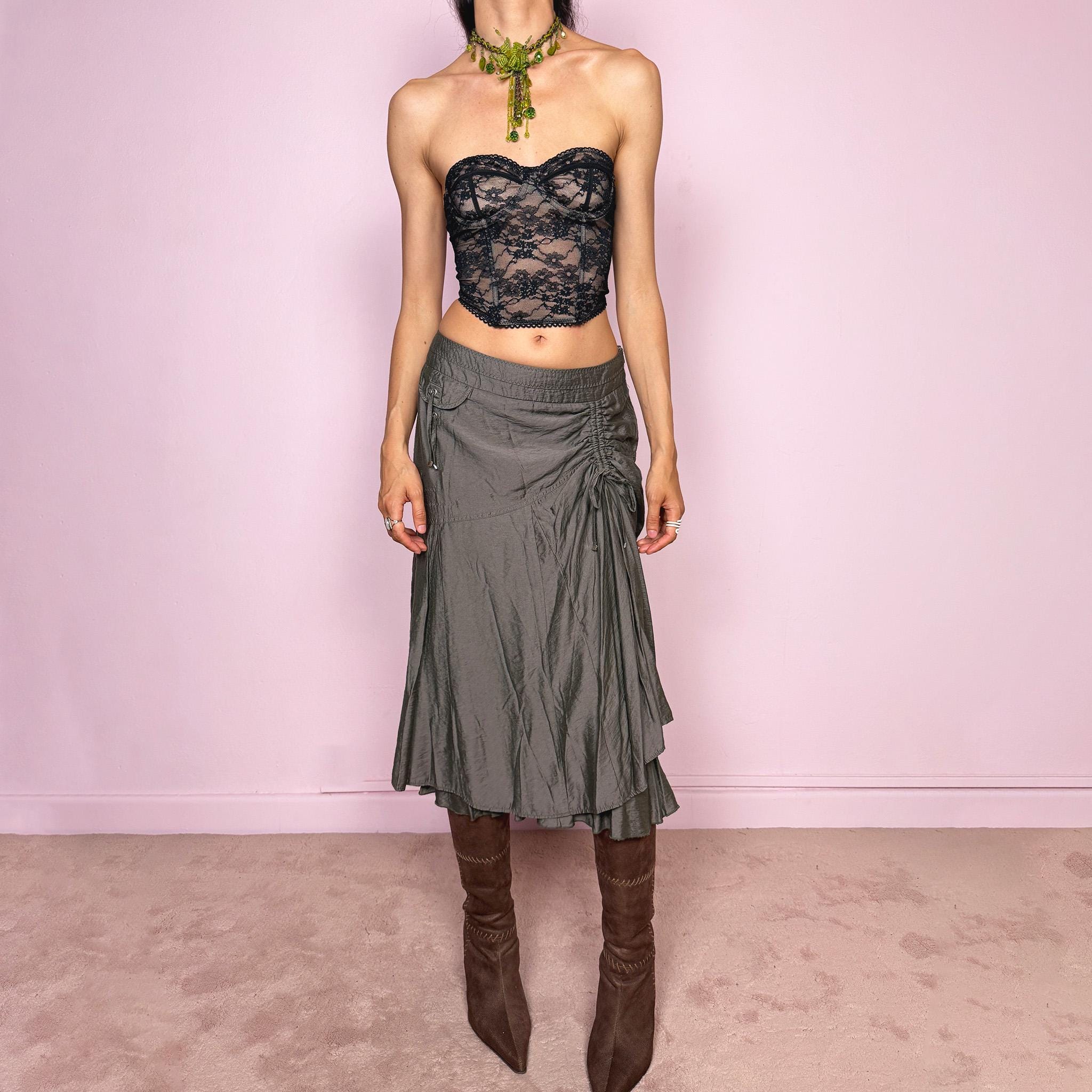 Vintage 2000s greenish-gray layered midi skirt featuring a fluid draped silhouette, ruched side detail with tie accents, and a softly flared layered hem. Designed in a non-stretch 83% viscose-blend fabric with a side zip closure and full polyester lining, the skirt has an avant-garde deconstructed aesthetic. Can be worn high-waisted for size L or lower-rise for M. Great vintage condition.