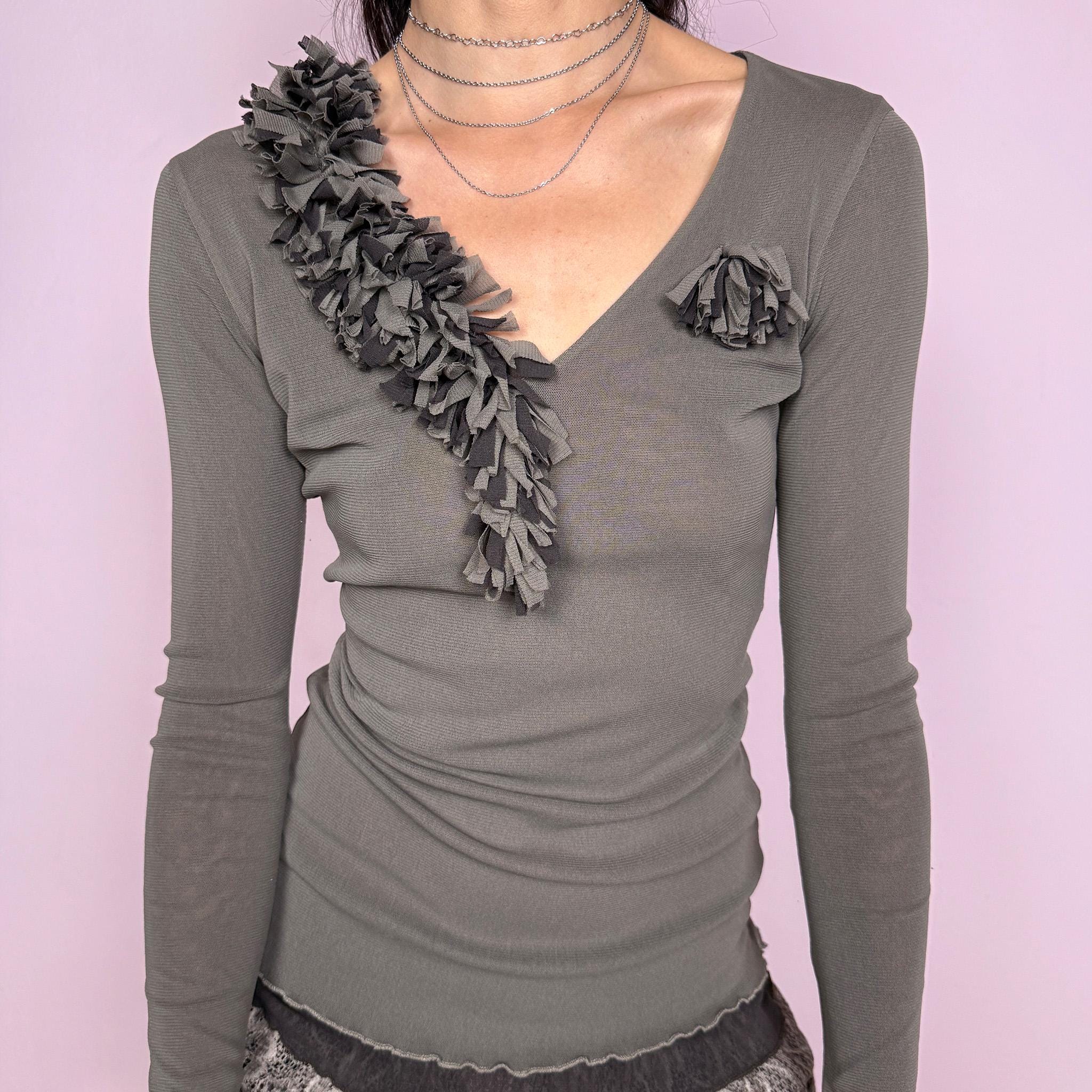 Vintage 2000s muted gray-taupe fitted long sleeve top in a stretchy double-layer mesh fabric, featuring a deep V neckline, sheer sleeves, delicate lettuce-edge trims, and textured ruffle floral appliqué details. Sleek, minimal avant-garde Y2K silhouette. Labels are missing. Excellent vintage condition.