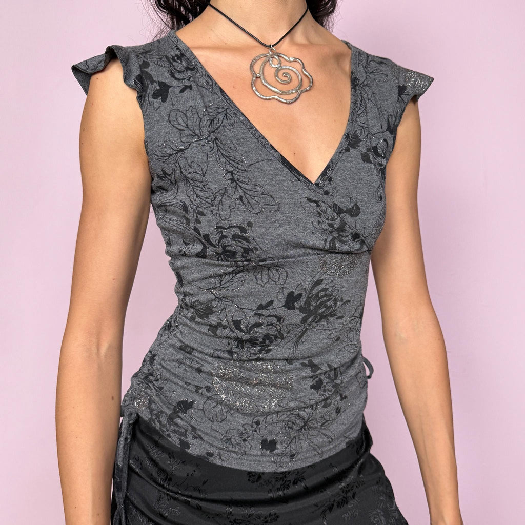 Cute soft vintage 2000s gray V neck wrap top with stretchy fitted silhouette. Black floral print with subtle glitter, ruched sides with adjustable tie drawstrings, and cap sleeves. Easy tee style for casual everyday wear, romantic coquette looks, night or day. Made from polyester polyamide blend. Great vintage condition.