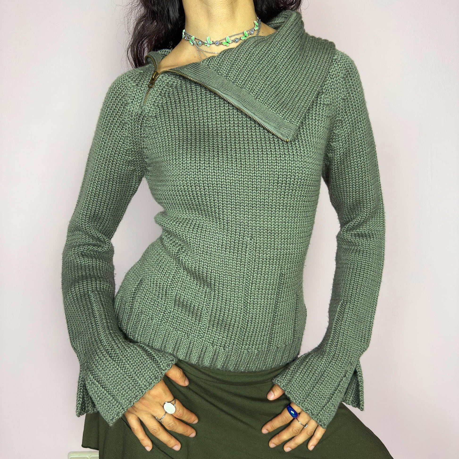 This vintage 2000s green knit sweater features a dramatic asymmetrical collar with exposed zipper and flared split cuffs. Ideal for deconstructed layering on autumn days, it radiates fairy grunge energy with a streetwear edge. A fluffy Y2K piece made of acrylic and wool for cozy warmth. Great vintage condition.