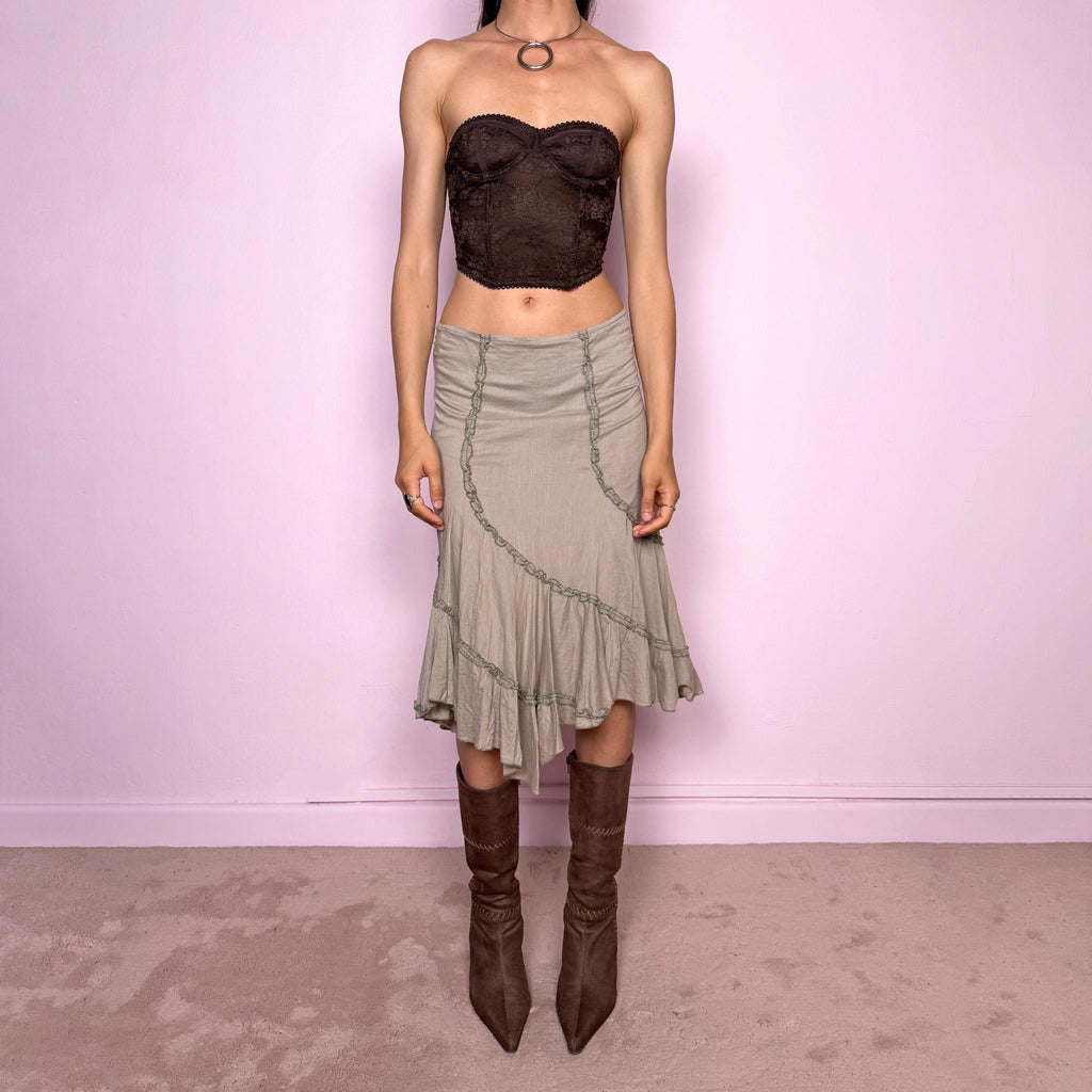 Vintage 2000s light khaki green asymmetric midi skirt made from 100% cotton. Features a side zip closure, no stretch, soft draped panels, and delicate ruffle trim detailing throughout the front and hem. A romantic Y2K bohemian piece in a muted taupe-khaki tone, perfect for fairy summer looks. Can be worn mid-rise for size S or lower rise for XS. Excellent vintage condition.