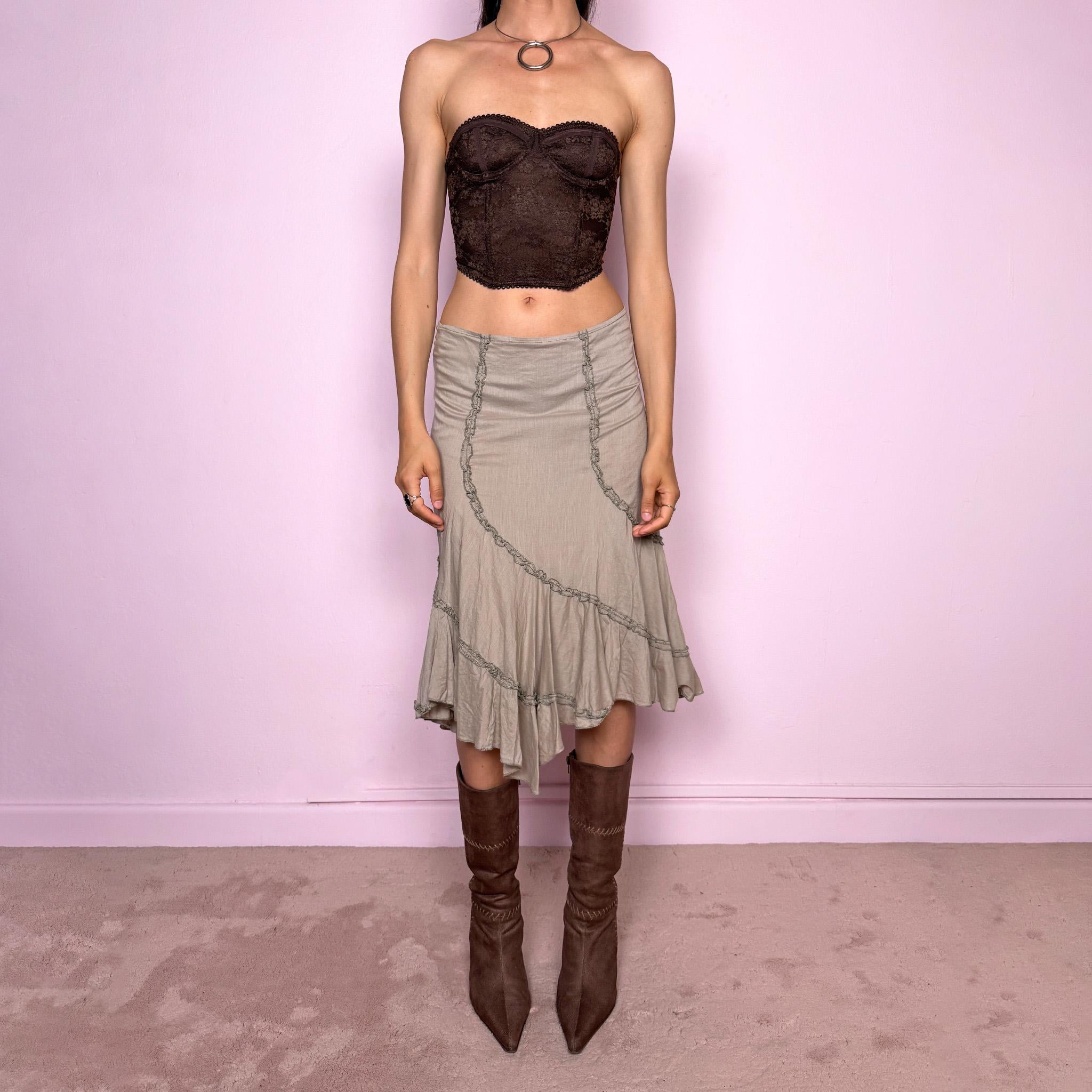 Vintage 2000s light khaki green asymmetric midi skirt made from 100% cotton. Features a side zip closure, no stretch, soft draped panels, and delicate ruffle trim detailing throughout the front and hem. A romantic Y2K bohemian piece in a muted taupe-khaki tone, perfect for fairy summer looks. Can be worn mid-rise for size S or lower rise for XS. Excellent vintage condition.