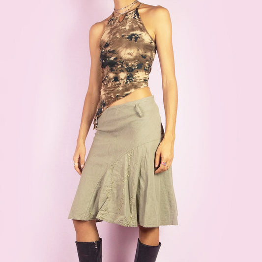 The Y2K Khaki Flared Trumpet Skirt is a vintage 2000s midi skirt crafted from a lightweight linen-cotton blend. It features a high-waisted fit with a side zipper closure, complemented by a flared trumpet silhouette with subtle embroidery details. Perfect for casual, boho-inspired summer and spring outfits.