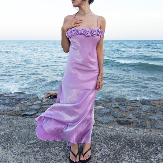 The vintage 2000s pastel lilac slip dress is a French-made fantasy with sculptural rosette appliqué along the bust. Its iridescent finish and fluid midi length evoke dreamy softness, perfect for proms, summer weddings, or romantic evenings. The silhouette captures fairytale allure with quiet glamour. A romantic Y2K archive crafted from a shimmering non-stretch polyester blend fabric. Excellent vintage condition.