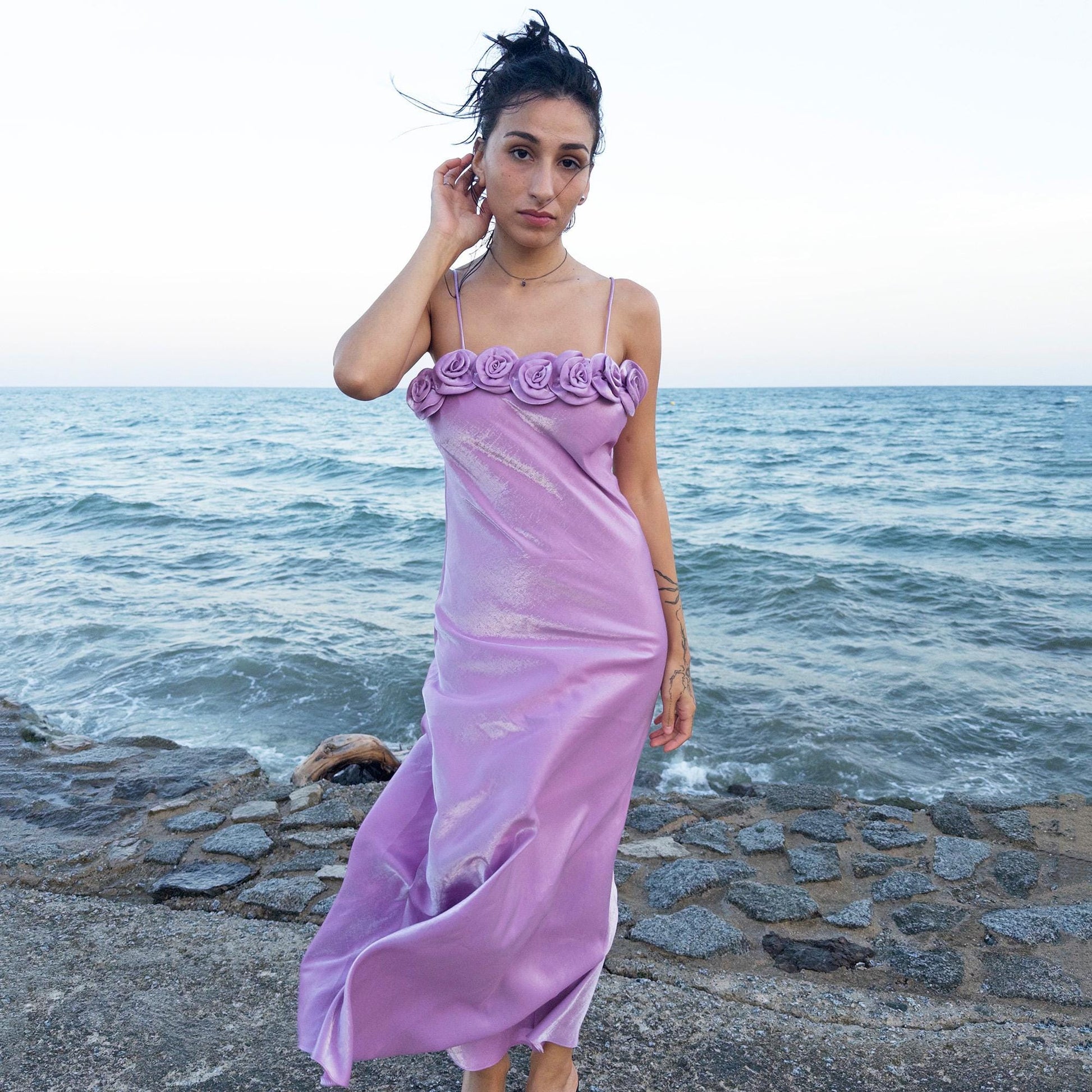 The vintage 2000s pastel lilac slip dress is a French-made fantasy with sculptural rosette appliqué along the bust. Its iridescent finish and fluid midi length evoke dreamy softness, perfect for proms, summer weddings, or romantic evenings. The silhouette captures fairytale allure with quiet glamour. A romantic Y2K archive crafted from a shimmering non-stretch polyester blend fabric. Excellent vintage condition.