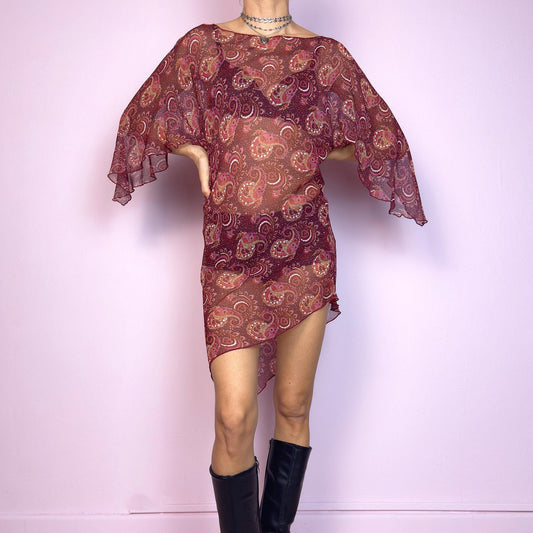 This vintage 2000s mini dress features a sheer burgundy paisley print, wide butterfly sleeves, and an asymmetric hem. Cut from lightweight fabric with no stretch, it drapes fluidly and falls mid-thigh with high side slits. Unlined and semi-transparent, perfect for layering or worn bold. A romantic Y2K silhouette with bohemian and fairycore energy—effortless, floaty, and made for summer nights. Great vintage condition.