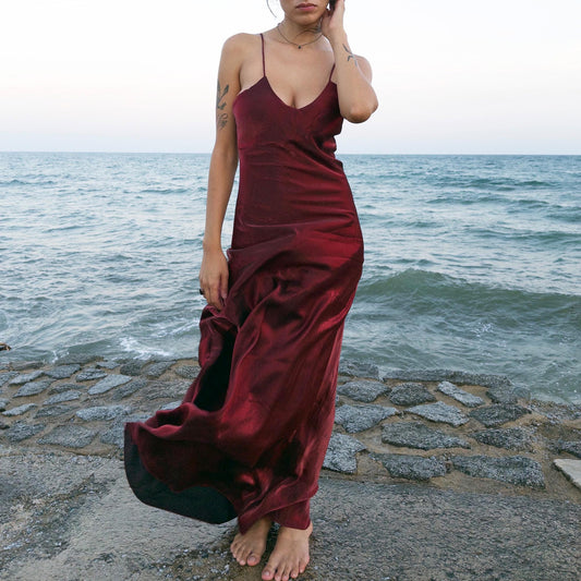 The vintage 2000s maroon slip dress is a French-made piece with high-shine finish, fluid silhouette, and delicate spaghetti straps. Its glossy depth and body-skimming cut evoke diva glamour and red carpet allure. Ideal for summer nights, cocktails, or sensual evening entrances. A romantic burgundy Y2K archive gown made from a non-stretch polyester blend fabric. Excellent vintage condition.