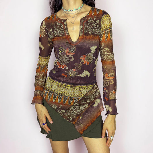 This vintage 2000s mesh top features an asymmetric hem and deep notched neckline. Designed with sheer long sleeves and a fitted cut, it showcases a rich floral and paisley print in earth tones of burnt orange, burgundy, and brown. Perfect for boho romantic whimsy wardrobes. Made from a stretch polyester and polyamide blend. Excellent vintage condition.