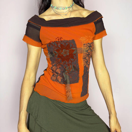 This vintage 2000s mesh top features a rich burnt orange and chocolate colorblock design with floral patchwork motifs. Designed with short sleeves, an off-the-shoulder neckline, and semi-sheer mesh accents, this fitted piece evokes bold, bohemian energy. A rare deconstructed artistic find from the Y2K era—perfect for statement dressing with a warm palette. Made of polyester blend. Excellent vintage condition.