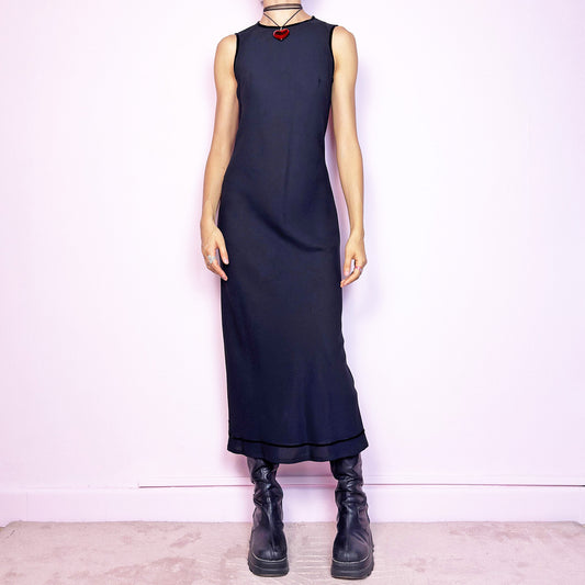 The Y2K Minimalist Black Midi Dress is a vintage 2000s sleek and timeless piece featuring a sleeveless design, and a slim, flattering fit. Crafted with lightweight, slightly sheer fabric, it drapes beautifully along the body and ends in a classic midi length. Features a back zipper closure and a back slit for ease of movement and an elegant touch. Perfect for minimalist, officecore, or elegant 90s-inspired looks. Effortlessly versatile for both casual layering and dressier night-out outfits. Made in Italy. 