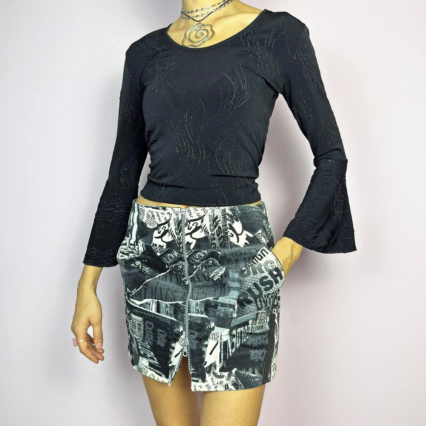 The Y2K Collage Print Mini Skirt is a vintage 2000s piece, featuring an all-over newspaper-inspired collage print in black and white. Designed with a low-rise fit, adjustable front zipper closure and pockets. The added cargo-style details and side zippers enhance its grunge aesthetic, making it perfect for alt, cyber, or casual looks. Great vintage condition.