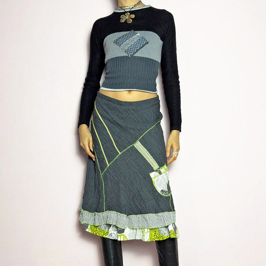 The Y2K Gray Patchwork Midi Skirt is a unique vintage 2000s piece featuring an eclectic mix of textures and contrasting neon green stitch details. Designed with a layered hem, ruffle trim, and a statement patch pocket with buckle detail, this skirt embodies a deconstructed boho aesthetic. The lightweight, crinkled fabric drapes effortlessly, while the elastic waistband ensures a comfortable fit, making it a perfect choice for bold, artsy outfits. Made in France.