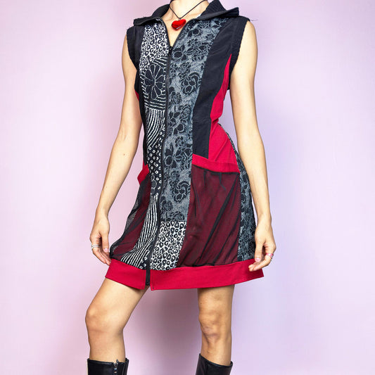 The Y2K Patchwork Zip-Up Mini Dress is a bold and sporty vintage 2000s mini dress featuring a mix of abstract floral, animal print, and geometric panels in black, red, and grey tones. Made with a stretchy base and breathable mesh pockets, it has a fitted silhouette with a front zip closure. The sleeveless design and patchwork look give off strong deconstructed and 2000s streetwear vibes. Perfect for alt nights, rave looks, or layering over mesh tops. Excellent vintage condition.