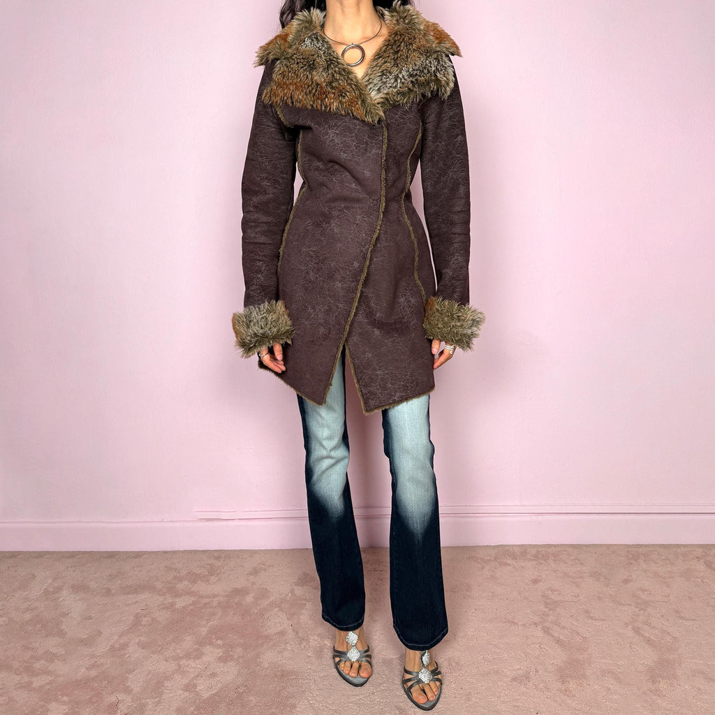Vintage 2000s brown long coat in a statement penny lane style with a fitted silhouette. Features snap button closure, matching fabric belt, and plush brown and beige faux fur lining at the collar and cuffs. Perfect for city girl winter and Y2K styling. Made from a polyester acrylic blend. Excellent vintage condition.