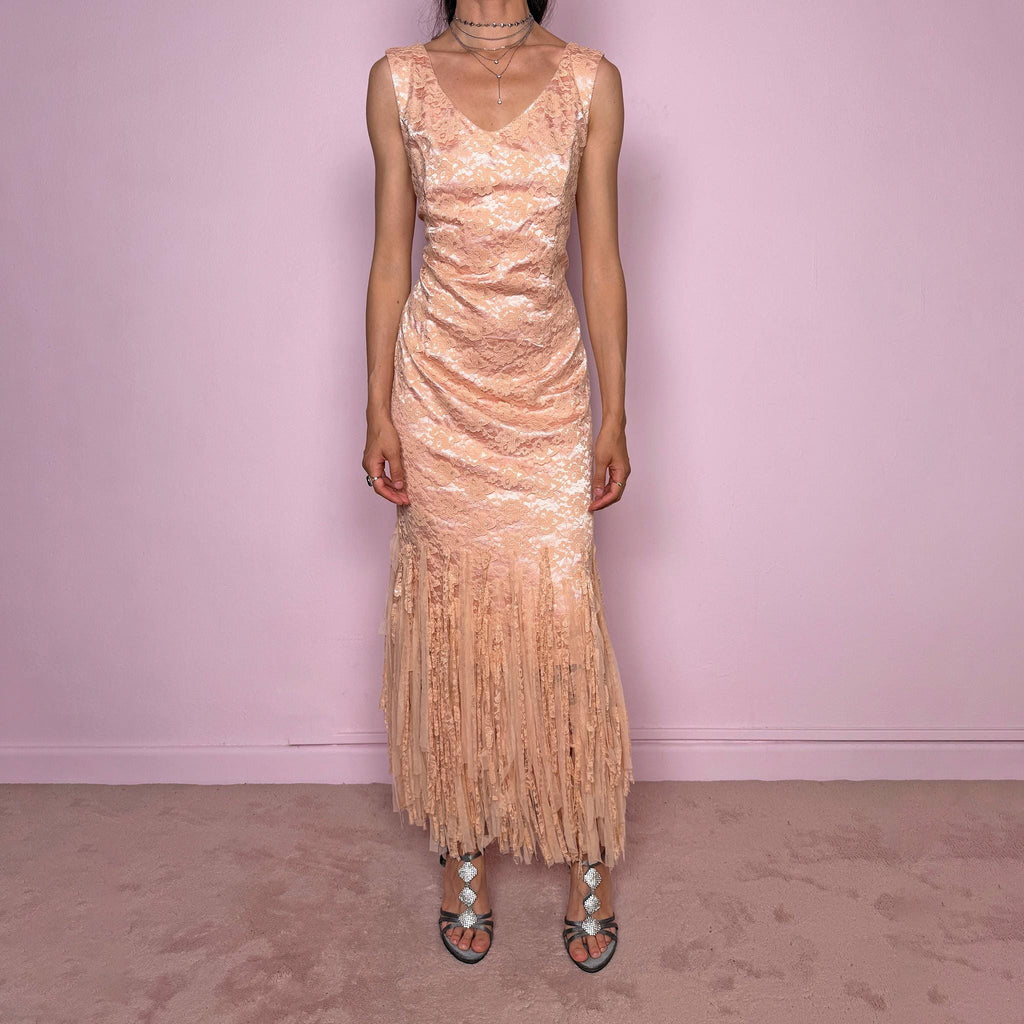 Vintage 2000s pastel peach lace maxi dress. Features a romantic V-neckline, fitted sleeveless silhouette, side zip closure, and a dramatic fringed lace hem. A refined occasion dress in a soft peach, salmon, and blush pink tone, perfect for romantic evening styling, spring-summer events, weddings, or elevated vintage looks. Made in Spain by a Spanish designer, with a nylon-cotton blend outer layer and polyester lining, with no stretch. Excellent vintage condition.