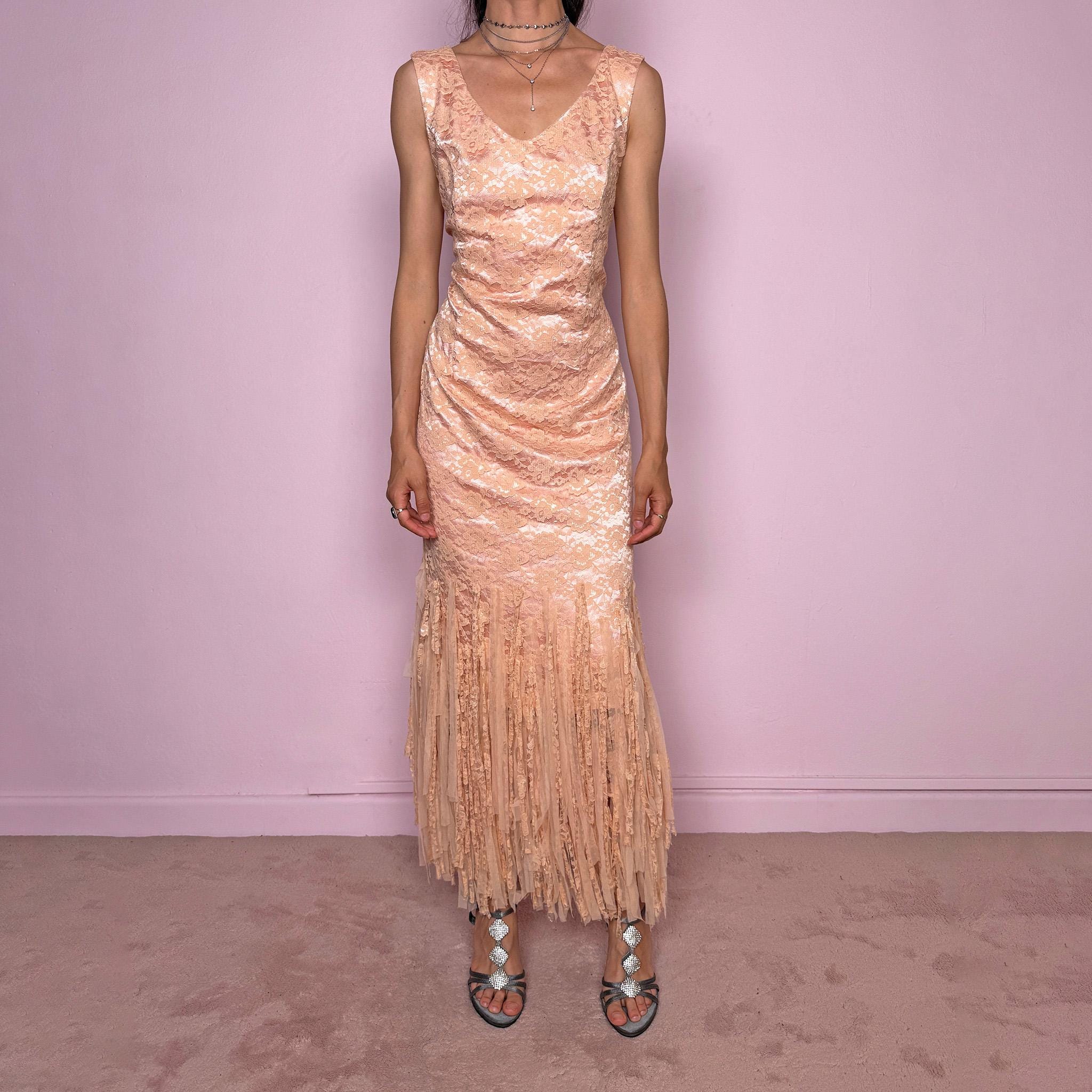 Vintage 2000s pastel peach lace maxi dress. Features a romantic V-neckline, fitted sleeveless silhouette, side zip closure, and a dramatic fringed lace hem. A refined occasion dress in a soft peach, salmon, and blush pink tone, perfect for romantic evening styling, spring-summer events, weddings, or elevated vintage looks. Made in Spain by a Spanish designer, with a nylon-cotton blend outer layer and polyester lining, with no stretch. Excellent vintage condition.