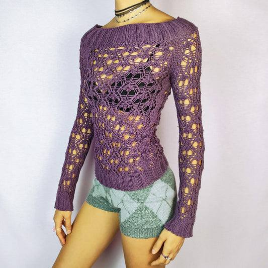 The Y2K Purple Crochet Boat Sweater is a vintage 2000s pullover featuring an intricate crochet-knit design, a boat neckline and long sleeves. Great vintage condition.