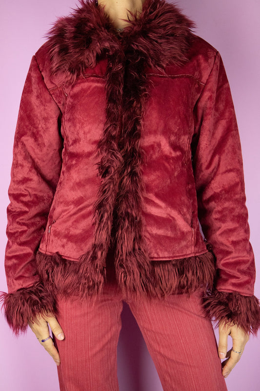 This vintage Y2K red Afghan-inspired jacket features soft faux suede with plush faux fur lining, collar, and cuffs. Designed with button closure and side pockets, it embodies the iconic Penny Lane silhouette, boho, fairy, and grunge all in one. A bold winter statement piece made from a polyester blend. Excellent vintage condition.
