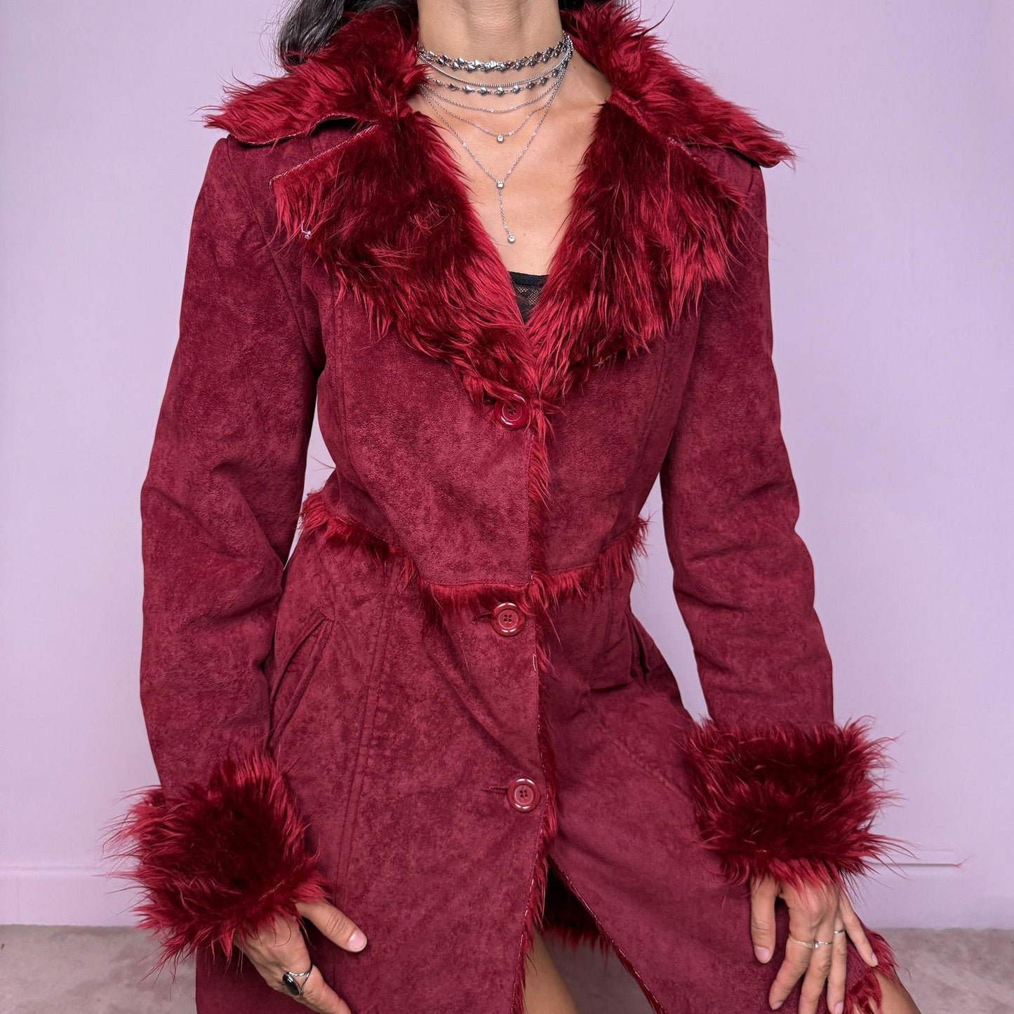 This vintage 2000s dark red Penny Lane coat features plush faux fur trim at the collar and cuffs, front buttons, and side pockets. Made from soft faux suede polyester, it captures glamorous Y2K fairy energy with a bold, whimsical edge. Perfect for winter styling, festivals, or statement nights out. Made from polyester faux suede. Excellent vintage condition.