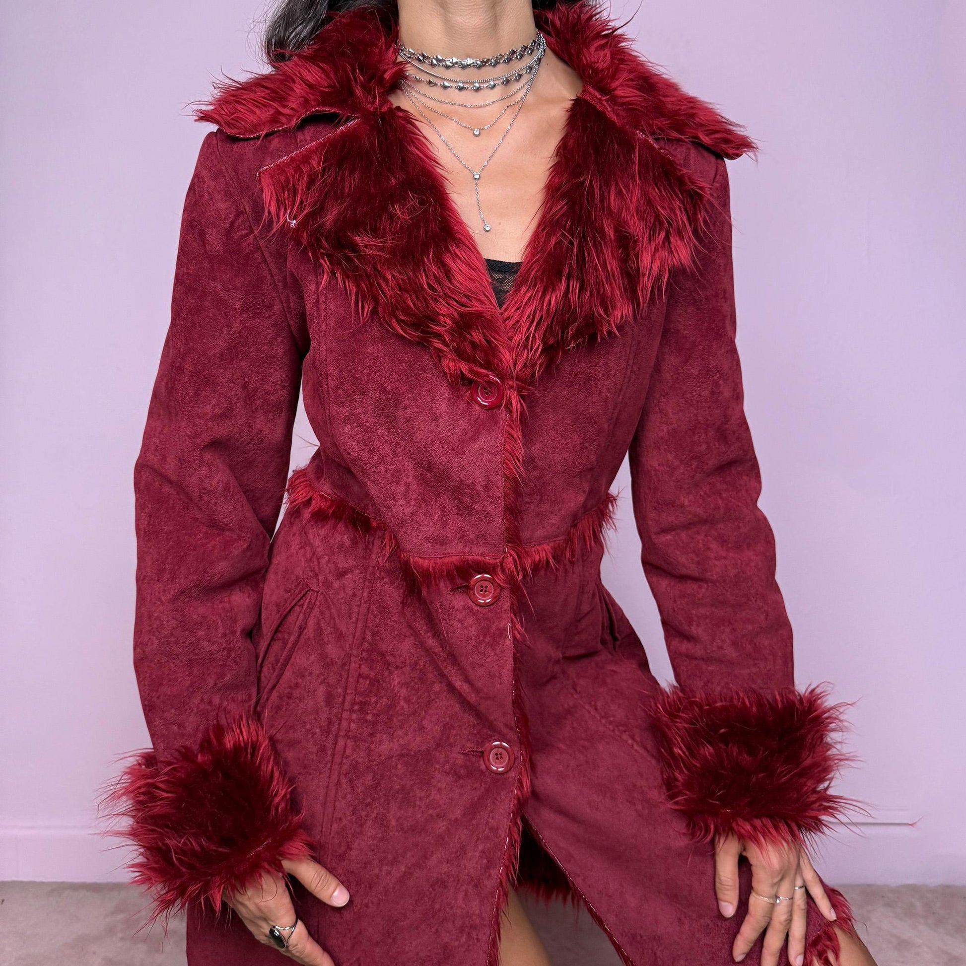 This vintage 2000s dark red Penny Lane coat features plush faux fur trim at the collar and cuffs, front buttons, and side pockets. Made from soft faux suede polyester, it captures glamorous Y2K fairy energy with a bold, whimsical edge. Perfect for winter styling, festivals, or statement nights out. Made from polyester faux suede. Excellent vintage condition.