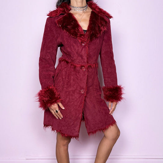 This vintage 2000s dark red Penny Lane coat features plush faux fur trim at the collar and cuffs, front buttons, and side pockets. Made from soft faux suede polyester, it captures glamorous Y2K fairy energy with a bold, whimsical edge. Perfect for winter styling, festivals, or statement nights out. Made from polyester faux suede. Excellent vintage condition.