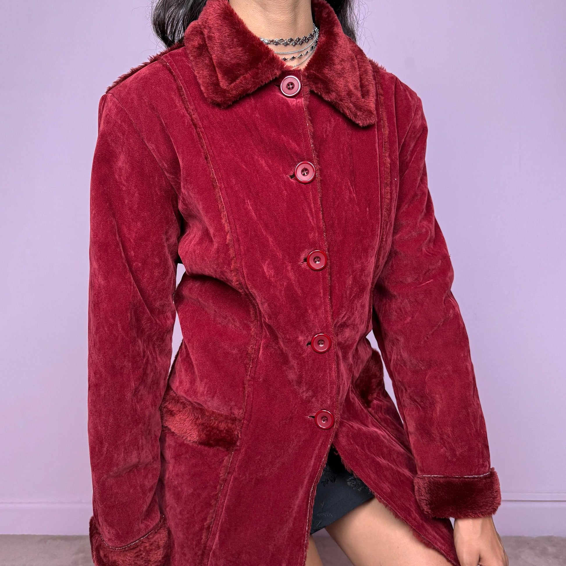 This vintage 2000s red faux suede coat features a plush faux fur lining, collar, and cuffs inspired by the iconic Penny Lane silhouette. Designed with front pockets and button closure, it captures whimsical Y2K winter charm with a boho-grunge edge, perfect for festivals or statement cold-weather styling. Made from polyester faux suede and faux fur. Great vintage condition.