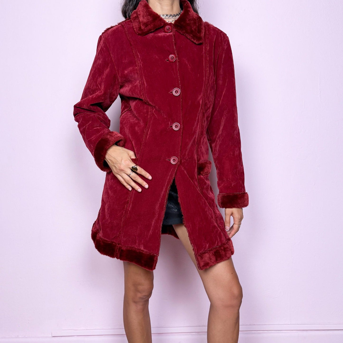 This vintage 2000s red faux suede coat features a plush faux fur lining, collar, and cuffs inspired by the iconic Penny Lane silhouette. Designed with front pockets and button closure, it captures whimsical Y2K winter charm with a boho-grunge edge, perfect for festivals or statement cold-weather styling. Made from polyester faux suede and faux fur. Great vintage condition.