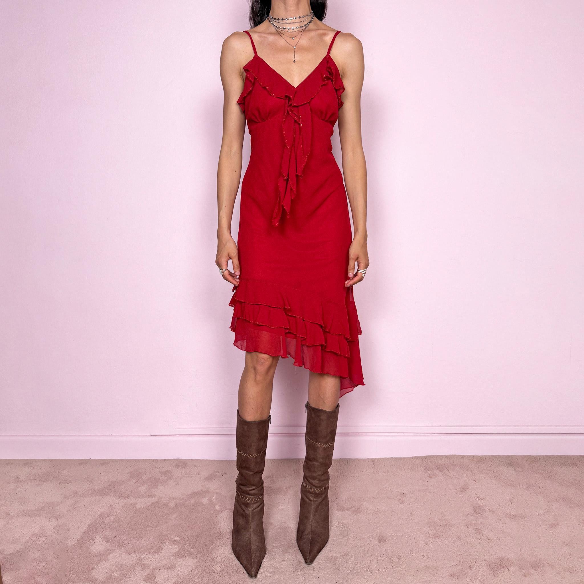 Vintage 2000s romantic red midi dress with a flattering V neckline and adjustable straps. Features delicate ruffle detailing at the bust, subtle beaded accents and an asymmetrical layered ruffle hem for fluid movement. Body-skimming fit with a dreamy coquette feel, perfect for summer parties or date nights. Great vintage condition.