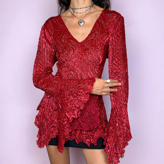 This vintage 2000s top features a dramatic red velvet devoré burnout design with sheer detailing. Styled with asymmetric bell sleeves, a fitted silhouette, and a flared hem, it creates a striking romantic look. Perfect for parties, festivals, or statement evening wear, this Y2K piece captures glamorous gothic energy with artistic flair. A rare archival French design. Made from a stretchy polyester blend devoré velvet. Excellent vintage condition.