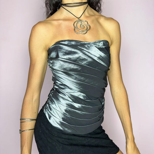 This vintage 2000s silver corset top features sculptural pleated draping over a glossy metallic base with internal boning and a back zipper closure. The strapless fit hugs the body in a sleek, structured silhouette, perfect for formal events, prom nights, or modern wedding styling. A rare Y2K statement piece with futuristic glam and dramatic polish—elevated yet bold, with impeccable shape and shine. Excellent vintage condition.