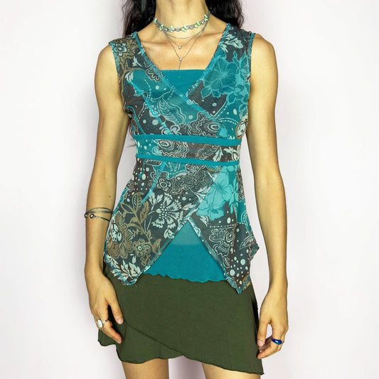 This vintage 2000s bohemian mermaidcore teal mesh wrap top blooms with layered floral motifs and boho swirls in sheer brown, beige, and aqua tones. The sleeveless silhouette features contrast piping and an asymmetric hem. Perfect for summer parties, festival layering, or vacation styling. A striking Y2K piece with romantic texture and carefree energy. Made of stretch polyester mesh. Excellent vintage condition.
