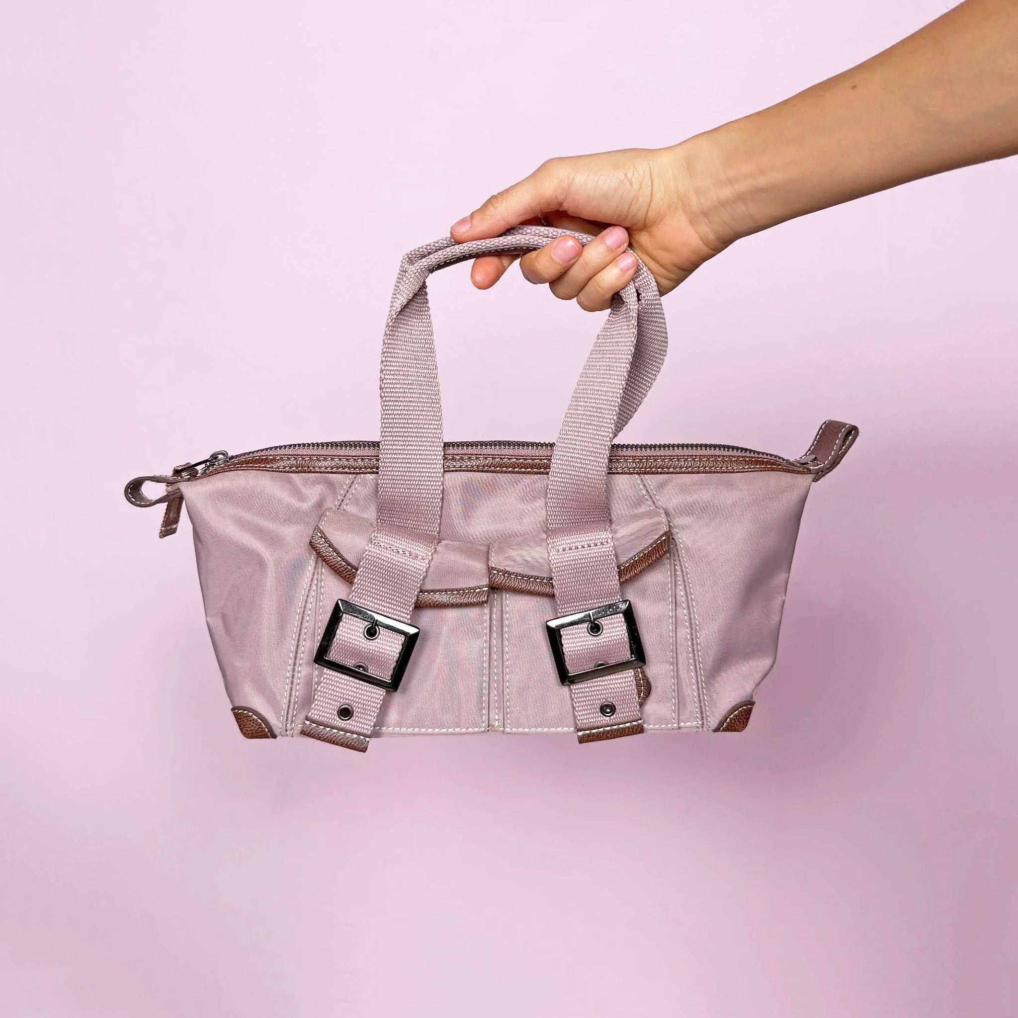Vintage 2000s minimalist tech top handle bag in muted pink-lilac with structured utilitarian silhouette. Features zip closure, front pockets with snap buttons, dark metal buckles, and double top handles. Includes interior pockets. French design by Une Après-Midi de Chien Paris. Made from polyamide and nylon blend. Excellent vintage condition.