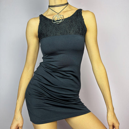 The Y2K Black Bodycon Mini Dress is a vintage 2000s piece featuring a delicate lace panel on the top with a sleek, stretchy fabric for a figure-hugging fit. Perfect for a night-out or party look. adult world shop