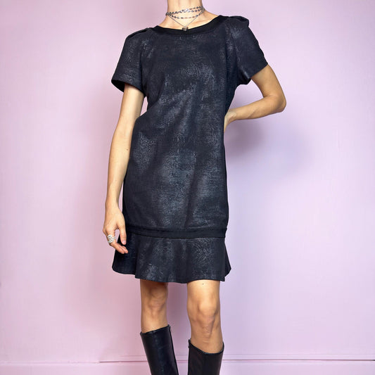 The Y2K Black Cop Copine Dress is a sleek and structured mini dress with subtle futuristic flair. Made from a soft black fabric with a slight sheen and textured abstract finish, it features short sleeves, a relaxed straight silhouette, and a ruffled hem for added movement. The back showcases a bold V-cut detail with a button closure at the neck. Unique yet minimalist, perfect for modern grunge or avant-garde looks. Made in Portugal. Excellent vintage condition.