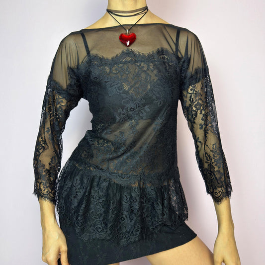 The Y2K Black Lace Peplum Top is a vintage 2000s piece featuring sheer mesh panels, floral lace detailing, and a flattering peplum hem. Designed with three-quarter length sleeves and a boat neckline for an elegant yet sultry silhouette. Perfect for layering or styling for a night out. Stretchy and lightweight for a comfortable fit. Excellent vintage condition. adult world shop