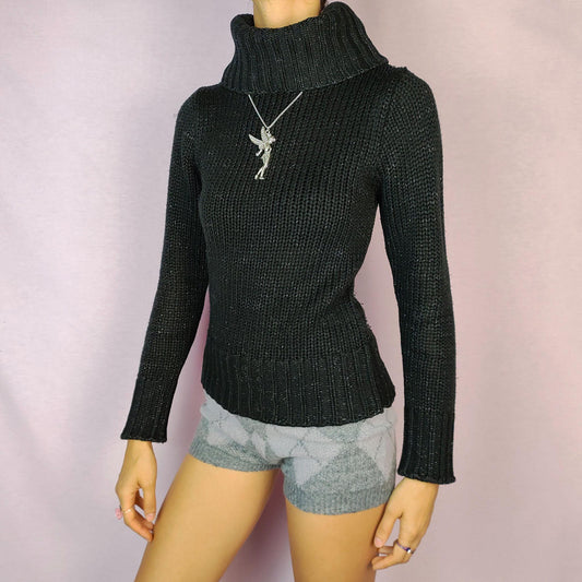 The Y2K Black Turtleneck Sweater is a vintage 2000s staple featuring a ribbed-knit design and a cozy oversized turtleneck. This timeless pullover is crafted from a stretchy fabric, offering both comfort and warmth. Perfect for casual winter looks.